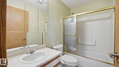 Full bathroom with shower / bath combination with glass door, vanity, and a textured ceiling - 1509 Jarvis Cr, Edmonton, AB - Indoor Photo Showing Bathroom