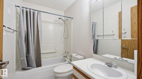 Bathroom featuring shower / bath combo, a textured ceiling, and vanity - 1509 Jarvis Cr, Edmonton, AB - Indoor Photo Showing Bathroom