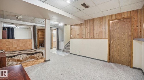 Finished below grade area with wooden walls, carpet flooring, and a drop ceiling - 1509 Jarvis Cr, Edmonton, AB - Indoor Photo Showing Other Room