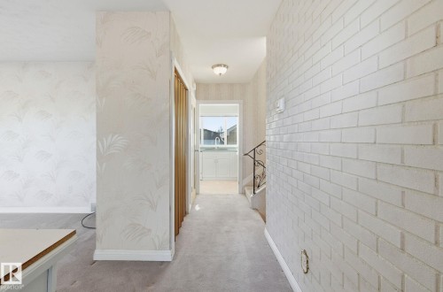 Hallway with wallpapered walls and light colored carpet - 12916 95A Street, Edmonton, AB - Indoor