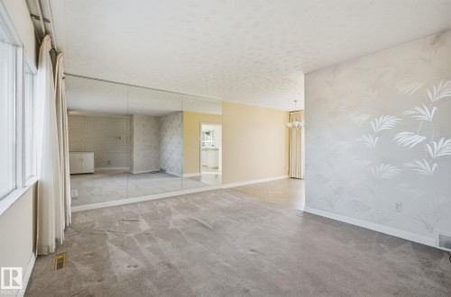 Carpeted empty room with wallpapered walls, a textured ceiling, and suspended lighting - 12916 95A Street, Edmonton, AB - Indoor Photo Showing Other Room