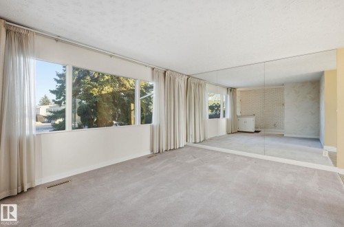Unfurnished living room featuring carpet flooring and a textured ceiling - 12916 95A Street, Edmonton, AB - Indoor Photo Showing Other Room