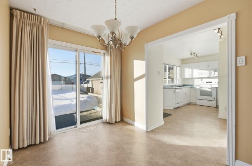 Unfurnished dining area featuring suspended lighting and concrete flooring - 12916 95A Street, Edmonton, AB - Indoor