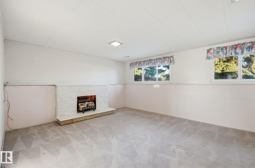 Unfurnished living room with a fireplace and carpet - 12916 95A Street, Edmonton, AB - Indoor Photo Showing Other Room