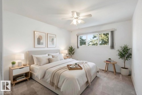 Bedroom with neutral-toned walls, carpeted flooring, a ceiling fan, and a window providing natural light and views of trees - 12916 95A Street, Edmonton, AB - Indoor Photo Showing Bedroom