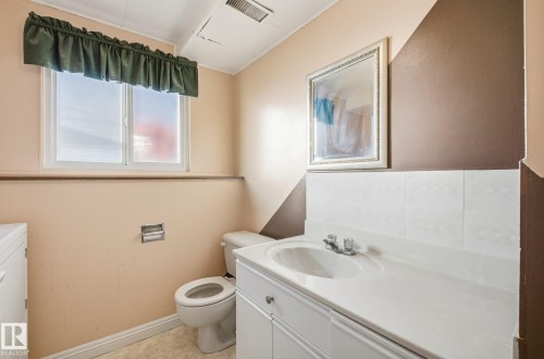 Half bath with vanity, washer / dryer, and light tile patterned flooring - 12916 95A Street, Edmonton, AB - Indoor Photo Showing Bathroom