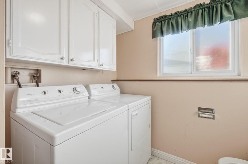 Laundry area featuring independent washer and dryer and cabinet space - 12916 95A Street, Edmonton, AB - Indoor Photo Showing Laundry Room