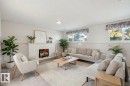 The living area features a white brick fireplace, recessed lighting, and windows that provide natural light - 12916 95A Street, Edmonton, AB  - Indoor Photo Showing Living Room With Fireplace 