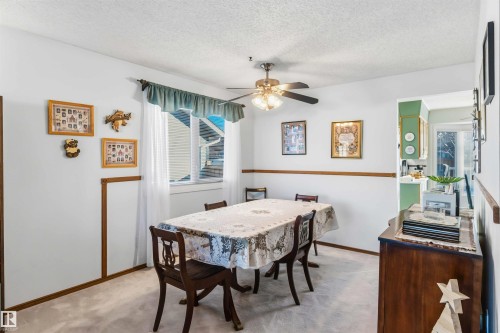 Dining room featuring light colored carpet, a textured ceiling, and a ceiling fan - 17619 94 Ave, Edmonton, AB - Indoor Photo Showing Dining Room