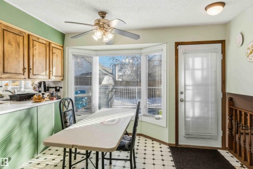 Dining space featuring a textured ceiling, healthy amount of natural light, ceiling fan, and light floors - 17619 94 Ave, Edmonton, AB - Indoor Photo Showing Dining Room