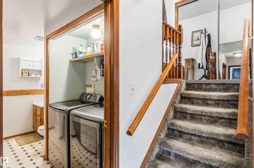 Stairway featuring tile patterned floors and separate washer and dryer - 17619 94 Ave, Edmonton, AB - Indoor