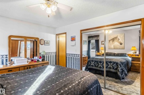 Bedroom featuring a textured ceiling, a closet, a ceiling fan, carpet floors, and wainscoting - 17619 94 Ave, Edmonton, AB - Indoor Photo Showing Bedroom