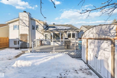 Snow covered property with a deck, an outbuilding, and a chimney - 17619 94 Ave, Edmonton, AB - Outdoor