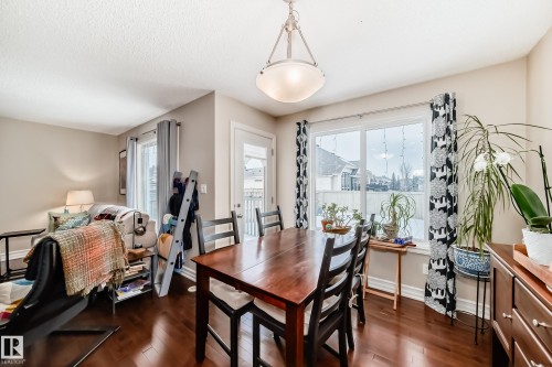 Dining area with dark wood finished floors and healthy amount of natural light - 9645 Simpson Place, Edmonton, AB 