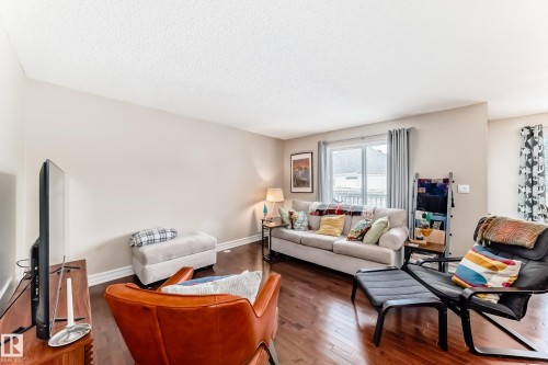 Living area featuring hardwood / wood-style floors and a textured ceiling - 9645 Simpson Place, Edmonton, AB 