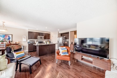 Living room featuring dark wood-style floors, recessed lighting, and a textured ceiling - 9645 Simpson Place, Edmonton, AB 
