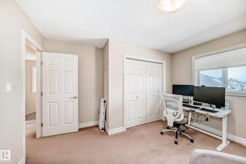 Office featuring light colored carpet, a textured ceiling, and radiator - 9645 Simpson Place, Edmonton, AB 