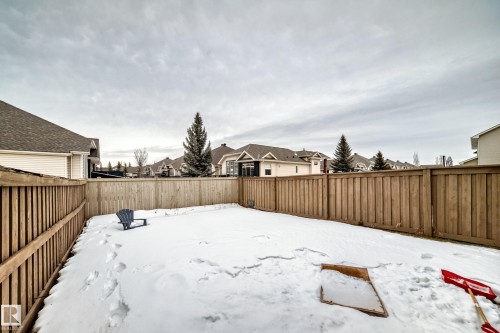 Yard layered in snow with a residential view and a fenced backyard - 9645 Simpson Place, Edmonton, AB 