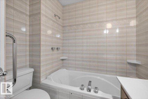 Full bathroom featuring tiled shower / bath, tile walls, and vanity - Edmonton, AB - Indoor Photo Showing Bathroom