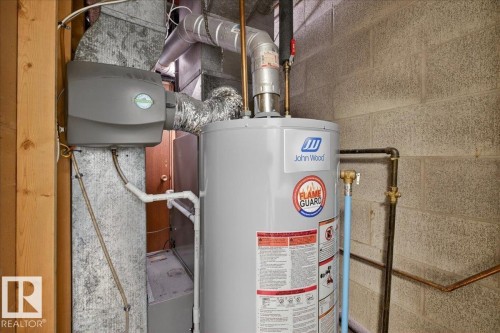 Utility room featuring gas water heater and heating unit - Edmonton, AB - Indoor Photo Showing Basement