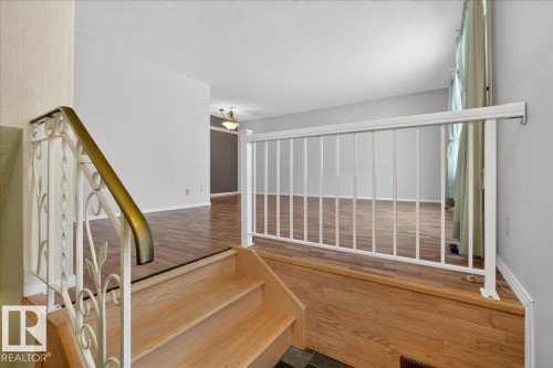 Stairs with wood finished floors and a textured ceiling - Edmonton, AB - Indoor Photo Showing Other Room