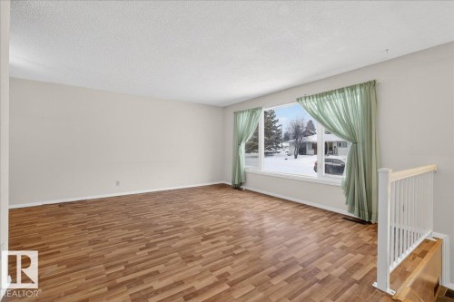 Spare room with a textured ceiling and light wood-style floors - Edmonton, AB - Indoor