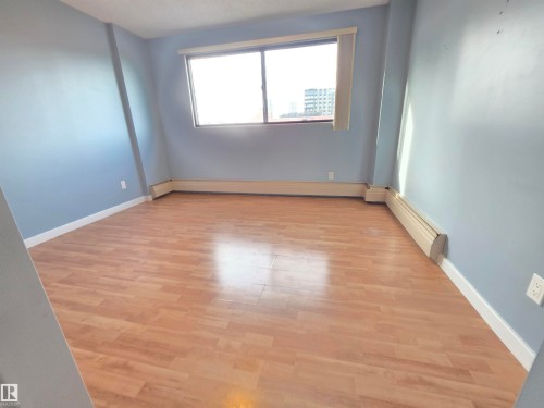 Unfurnished room featuring baseboard heating and light wood finished floors - 701 10155 114 Street, Edmonton, AB - Indoor Photo Showing Other Room