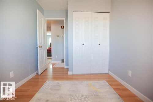 Unfurnished bedroom featuring light wood-style floors, a closet, and a textured ceiling - 17208 106 Street, Edmonton, AB - Indoor Photo Showing Other Room