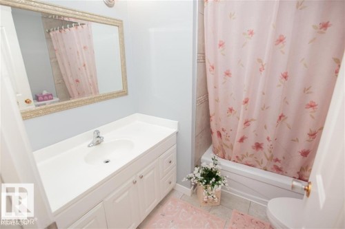 Full bathroom featuring vanity, shower / bath combo, and light tile patterned floors - 17208 106 Street, Edmonton, AB - Indoor Photo Showing Bathroom