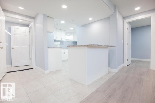 Kitchen featuring white cabinets, recessed lighting, a peninsula, and light tile patterned floors - 17208 106 Street, Edmonton, AB - Indoor Photo Showing Other Room