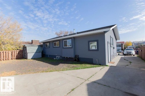 View of side of property featuring stucco siding and a storage shed - 17208 106 Street, Edmonton, AB - Outdoor With Exterior