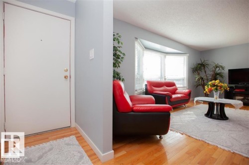 Entrance foyer featuring light wood finished floors and a textured ceiling - 17208 106 Street, Edmonton, AB - Indoor Photo Showing Living Room