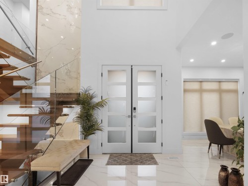 Foyer entrance with french doors, light marble finish flooring, recessed lighting, and a high ceiling - 4809 Woolsey Lane, Edmonton, AB - Indoor Photo Showing Other Room
