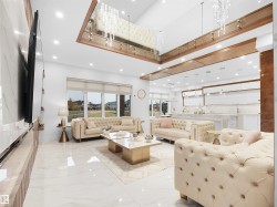 Living area with a high ceiling, light marble finish flooring, and recessed lighting - 