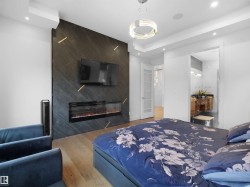 Bedroom with wood finished floors, ensuite bathroom, a fireplace, and recessed lighting - 