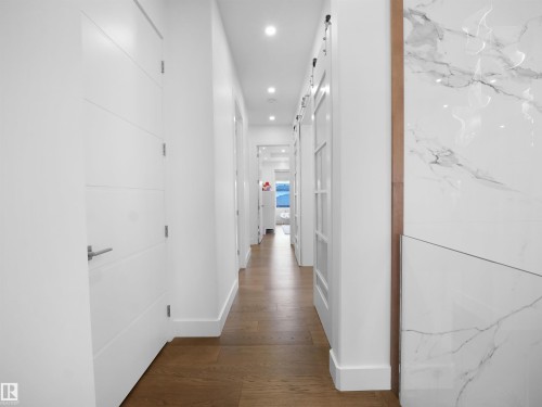 Hall featuring a barn door, recessed lighting, and dark wood finished floors - 4809 Woolsey Lane, Edmonton, AB - Indoor Photo Showing Other Room