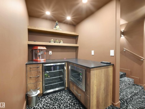 Indoor dry bar with open shelves, beverage cooler, stainless steel microwave, modern cabinets, and recessed lighting - 4809 Woolsey Lane, Edmonton, AB - Indoor Photo Showing Other Room
