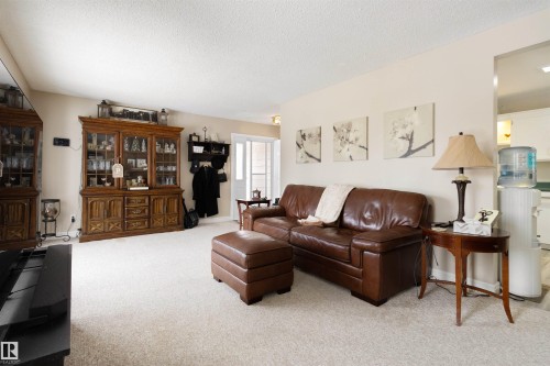 Living room with light colored carpet and a textured ceiling - 4423 18 Avenue, Edmonton, AB - Indoor Photo Showing Living Room