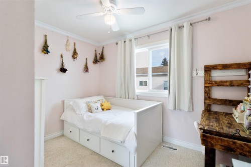 Bedroom featuring crown molding, a ceiling fan, and dark aggregate flooring - 4423 18 Avenue, Edmonton, AB - Indoor Photo Showing Bedroom