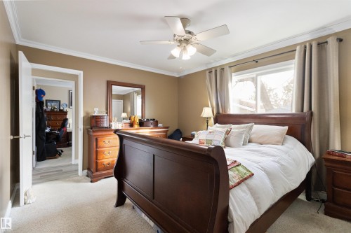 Bedroom featuring light carpet, ornamental molding, and ceiling fan - 4423 18 Avenue, Edmonton, AB - Indoor Photo Showing Bedroom