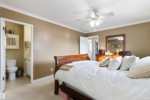 Bedroom with ornamental molding, a ceiling fan, ensuite bathroom, and light carpet - 4423 18 Avenue, Edmonton, AB - Indoor Photo Showing Bedroom