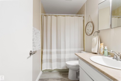 Full bathroom featuring vanity, curtained shower, and light wood finished floors - 4423 18 Avenue, Edmonton, AB - Indoor Photo Showing Bathroom