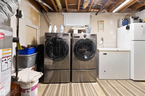 Laundry area featuring water heater and independent washer and dryer - 4423 18 Avenue, Edmonton, AB - Indoor Photo Showing Laundry Room