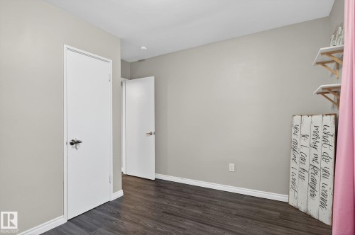 Unfurnished bedroom featuring baseboards and dark wood-type flooring - 5 Langley Drive, Fort Saskatchewan, AB - Indoor Photo Showing Other Room