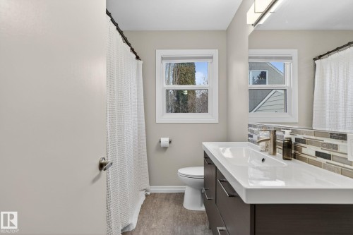 Bathroom featuring curtained shower, vanity, and decorative backsplash - 5 Langley Drive, Fort Saskatchewan, AB - Indoor Photo Showing Bathroom