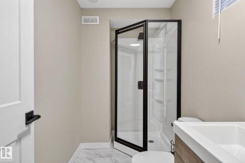 Full bathroom with a stall shower, vanity, and light marble finish floors - 5 Langley Drive, Fort Saskatchewan, AB - Indoor Photo Showing Bathroom
