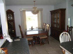 Dining room featuring crown molding, light tile patterned flooring, plenty of natural light, a textured ceiling, and a chandelier - 