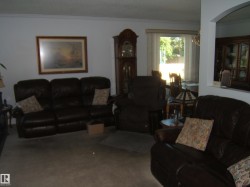 Living area featuring crown molding, carpet floors, and a chandelier - 