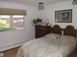 Bedroom with wood finished floors and baseboard heating - 
