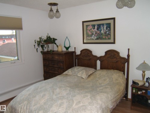 Bedroom featuring wood finished floors and a baseboard radiator - 4807 54 Avenue, Two Hills, AB - Indoor Photo Showing Bedroom